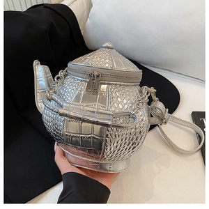 Close-up of silver teapot shaped bag with crocodile texture and metallic finish