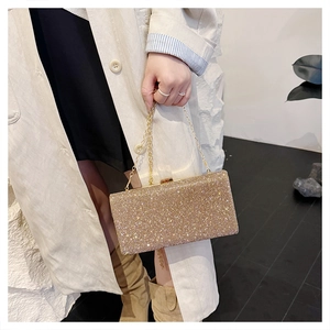 Detail of elegant gold evening clutch bag with shimmering crystals and chain strap