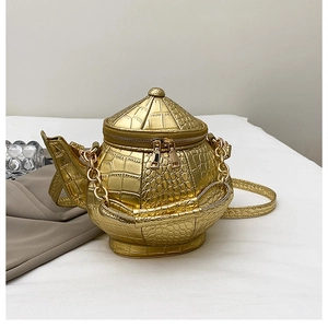 Detailed view of creative gold teapot shaped crossbody bag with crocodile texture leather