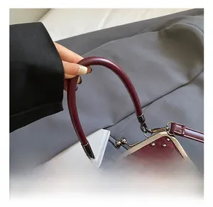 Detail of burgundy fringe bag featuring silver rivets and retro metal kiss-lock closure