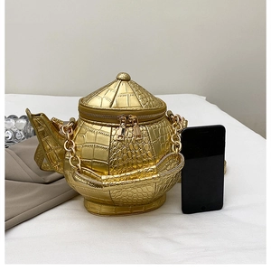 Detailed view of the gold 3D flask-shaped bag featuring crocodile leather texture and chain