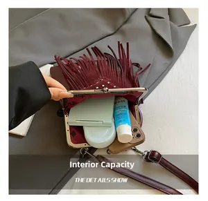 Interior view of vintage burgundy fringe bag showing storage capacity for cosmetics