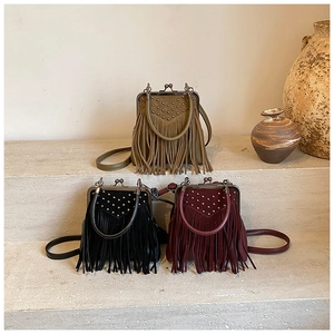 Three vintage rivet bags with fringe in olive, black and burgundy on stone stairs