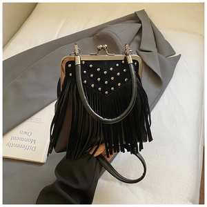 Detailed view of vintage black suede handbag with rivet decor and long tassels