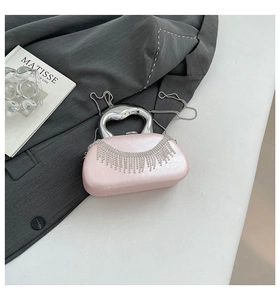 Detail of pink satin evening bag with rhinestone fringe and metallic top handle
