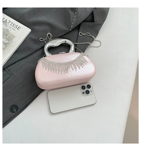 Detailed view of pink evening bag with rhinestone fringe and heart-shaped metal handle