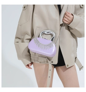 Close-up of light purple evening bag with rhinestone tassels and silver U-shaped handle