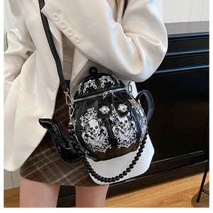 Detail of 3D teapot crossbody bag with skull floral print and decorative bead chain