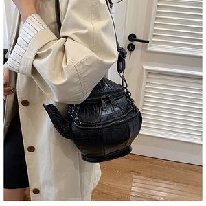 Detailed view of crocodile pattern leather texture on a 3D teapot-shaped crossbody bag