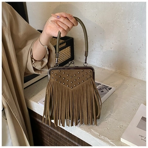 Detail of vintage brown suede handbag with metal studs, fringe accents and doctor bag clasp