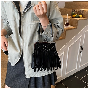 Macro detail of black vintage handbag with silver rivets and long leather fringes
