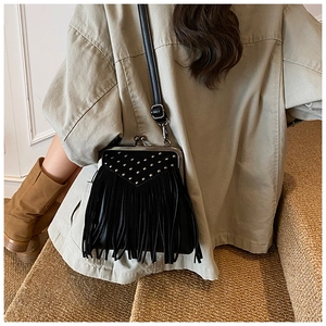 Detail of vintage black tassel bag with silver rivets and metal clasp on street