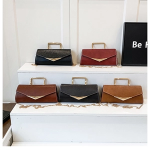 Close-up of small crossbody envelope bags with metal handles and gold chain straps
