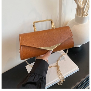 Close-up of brown litchi pattern leather bag with golden V-metal and square handle