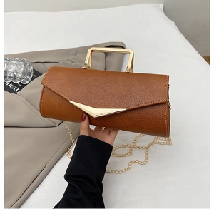 Detail of brown litchi pattern leather bag with golden V-metal clasp and chain strap