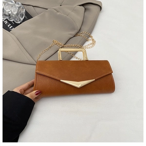 Detail of caramel leather small square bag with V-shaped buckle and gold chain strap