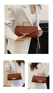 Detail of classic brown leather handbag with gold metal handle and V-shaped clasp lock