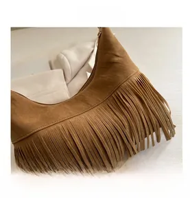 Detailed close-up of brown suede hobo bag featuring retro fringe and metal zipper design