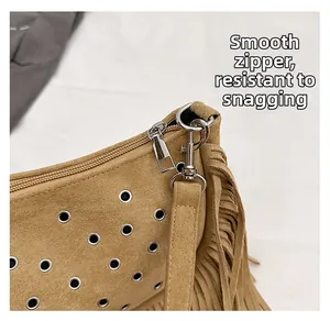 Détail de la fermeture éclair en métal et du crochet argenté sur le sac besace en daim