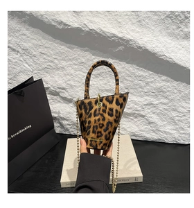 Detail of leopard print mini bucket bag with gold bead chain and fashion branding