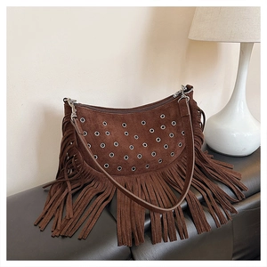 Détail du sac bohème en daim marron foncé avec de longues franges et des oeillets argentés
