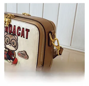 Detail of gold metal hook and leather trim on the cute cartoon bear crossbody bag