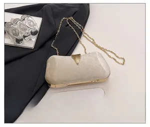 Champagne velvet evening clutch size comparison with smartphone and gold leaf clasp