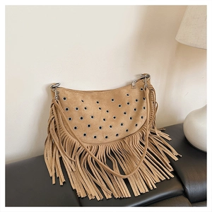 Détail du sac besace bohème en daim camel avec œillets métalliques et longues franges