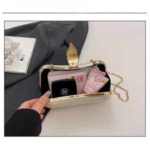 Detailed capacity of gold glitter evening clutch bag with leaf clasp and metal chain