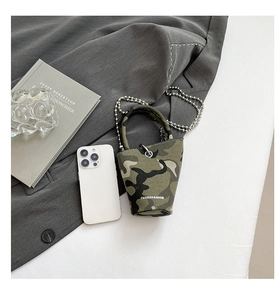 Detailed top view of a mini camouflage bucket bag on grey suit with silver bead chain