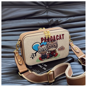 Detail of cartoon cat crossbody bag with adjustable wide shoulder strap and gold hardware