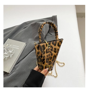 Detailed macro of leopard print mini bucket bag with gold chain and metal hardware
