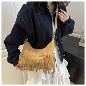 Close-up of camel suede tote bag featuring vintage long tassels and soft leather texture