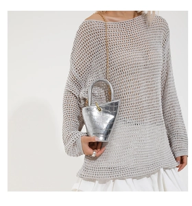Detailed macro view of silver mini bucket bag with crocodile texture and gold chain strap