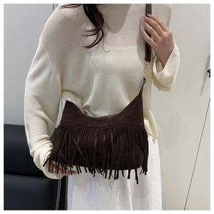 Detail of dark brown suede shoulder bag with dense tassels and gold metal hardware