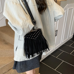 Fashionable black faux leather shoulder bag with silver rivets and long fringe tassels