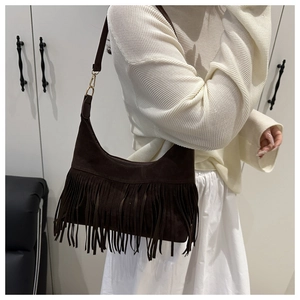 Detail of dark brown suede shoulder bag with dense fringe tassels and gold hardware