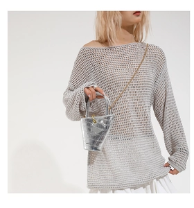 Detail of silver crocodile-pattern bucket bag with gold chain and metal handle