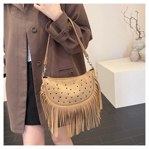 Detail of khaki faux suede bag featuring metallic eyelets and long bohemian fringes