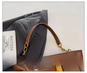 Detail of a brown pleated cloud bag featuring gold metal hardware and chain strap