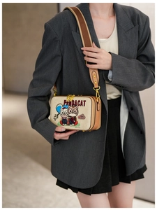 Detail of cute panda cat cartoon print on beige crossbody bag with fabric strap