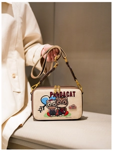 Detail of cream canvas crossbody bag with cat embroidery and wide shoulder strap