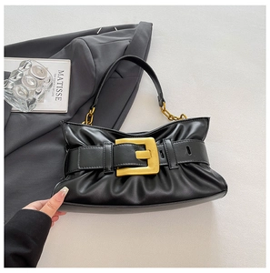 Detail of black pleated cloud bag featuring large gold buckle and metal chain strap