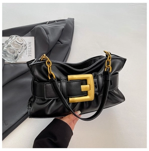 Close-up of black pleated cloud bag featuring matte gold square buckle and chain handle
