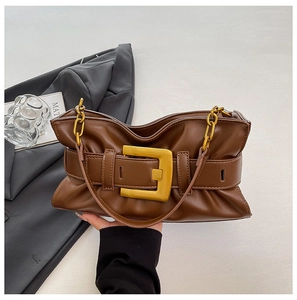 Detailed shot of brown pleated cloud bag featuring large gold buckle and metal chain handle