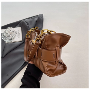Detail of dark brown leather cloud bag with gold chain and buckle side decoration