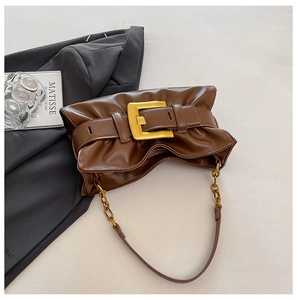 Detail view of a vintage dark brown ruched bag with a large gold square buckle