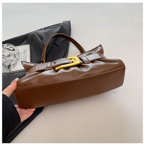 Detailed view of brown faux leather tote with large gold square buckle and retro strap