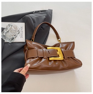 Detail view of brown pleated cloud bag featuring large gold buckle and luxury leather texture