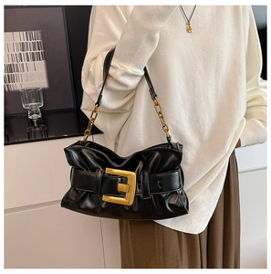Close-up of black pleated cloud bag with large gold square buckle and chain strap